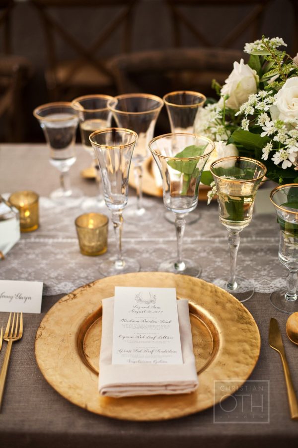 gold flatware with gold rimmed glasses and lace table runners